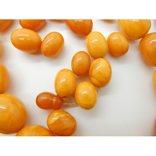 684 - TWO STRINGS OF AMBER COLOURED BEADS