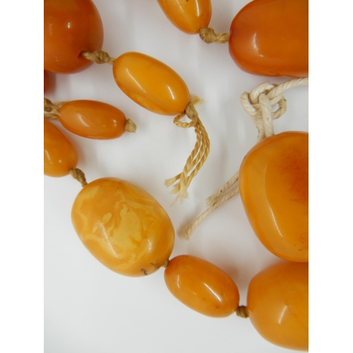 687 - A LONG STRING OF AMBER COLOURED BEADS (AF)