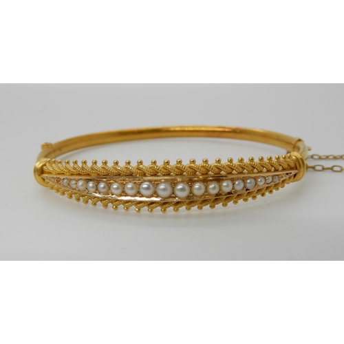 691 - A 15CT GOLD PEARL SET BANGLE