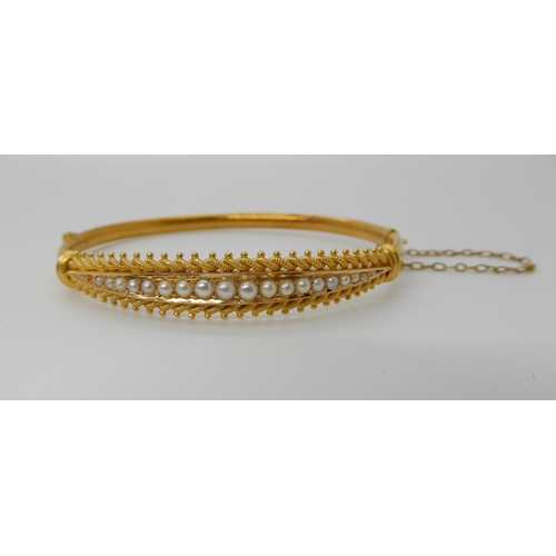 691 - A 15CT GOLD PEARL SET BANGLE