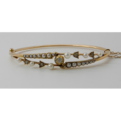 720 - A YELLOW METAL PEARL AND DIAMOND BANGLE