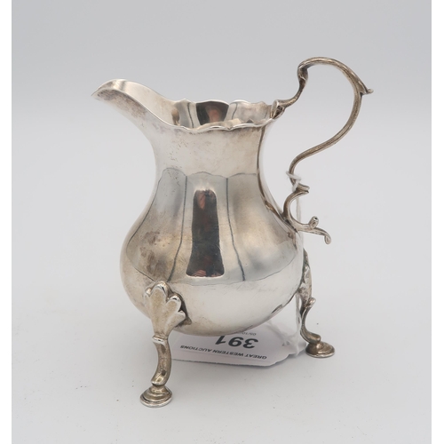 391 - An early George III silver cream jug, of baluster form with an S scroll handle, supported on three h... 