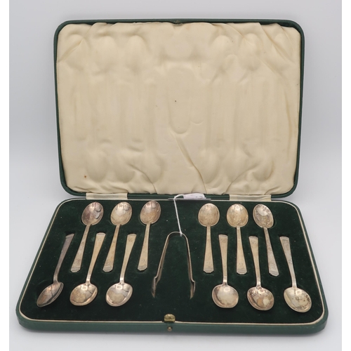 405 - A cased set of twelve silver spoons and sugar tongs, with shaped terminals, by C W Fletcher & So... 