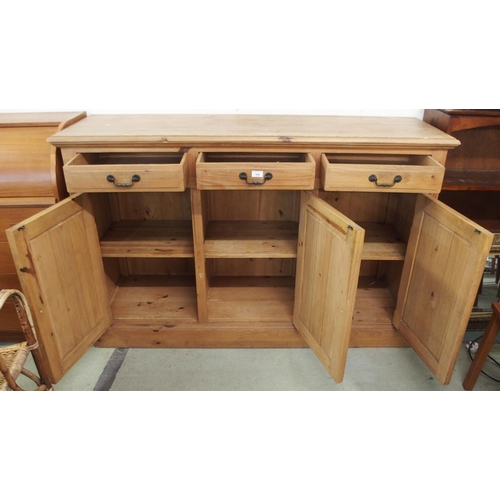 100 - A 20th century pine sideboard with three drawers over three gothic style carved panel cabinet doors,... 