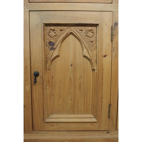 100 - A 20th century pine sideboard with three drawers over three gothic style carved panel cabinet doors,... 