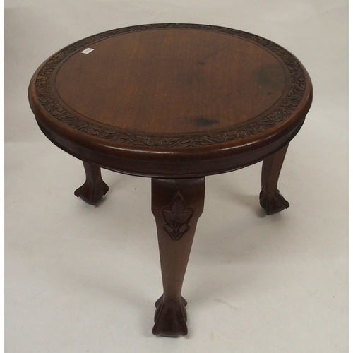 103 - A 20th century Chinese hardwood occasional table with extensively carved top depicting village scene... 