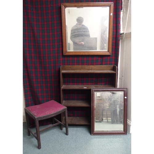 11 - A 20th century oak open bookcase, two bevelled glass wall mirrors and an upholstered stool (4)