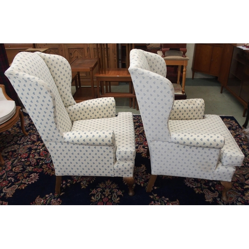 110 - A pair of 20th century wing back armchairs with white patterned upholstery on cabriole supports (2)