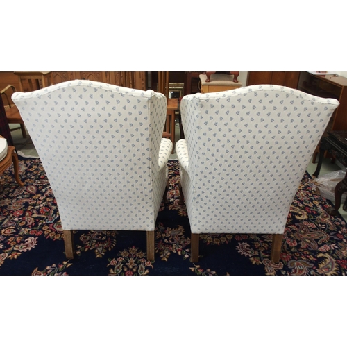 110 - A pair of 20th century wing back armchairs with white patterned upholstery on cabriole supports (2)