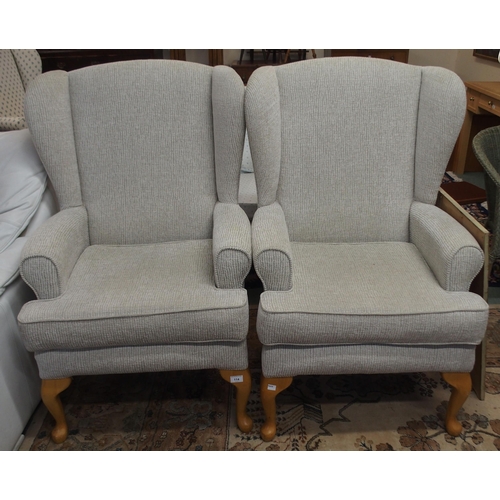 114 - A pair of contemporary wing back armchairs with light grey upholstery on cabriole supports (2)