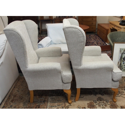 114 - A pair of contemporary wing back armchairs with light grey upholstery on cabriole supports (2)