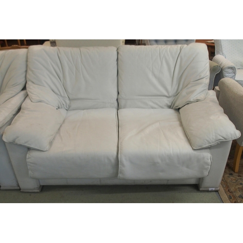 115 - A 20th century white leather upholstered two seater sofa, 85cm high x 140cm wide x 95cm deep