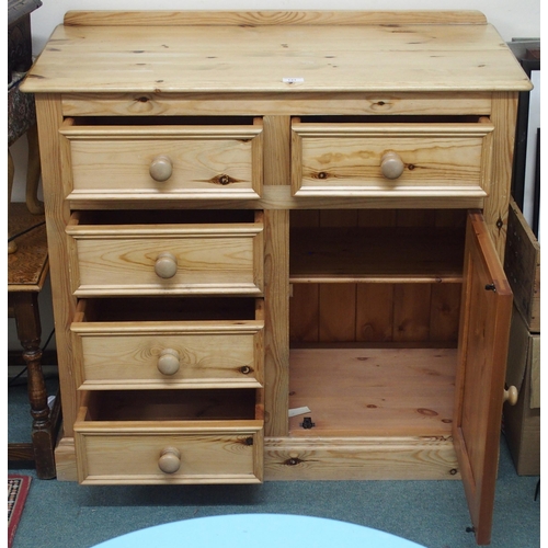 121 - A 20th century pine bedroom chest with two short drawers over three short drawers beside cabinet doo... 