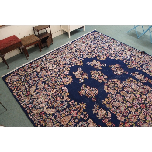 85 - A dark blue ground eastern style wool rug with floral foliate central medallion and borders, 501cm l... 