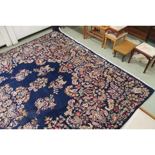 85 - A dark blue ground eastern style wool rug with floral foliate central medallion and borders, 501cm l... 