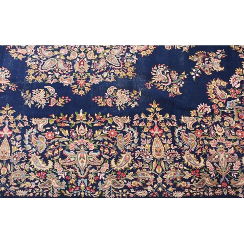 85 - A dark blue ground eastern style wool rug with floral foliate central medallion and borders, 501cm l... 