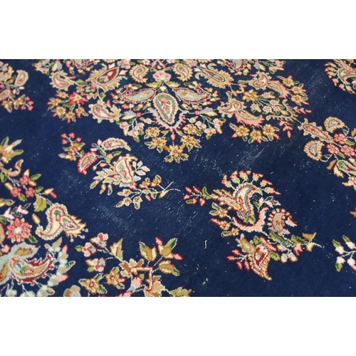 85 - A dark blue ground eastern style wool rug with floral foliate central medallion and borders, 501cm l... 