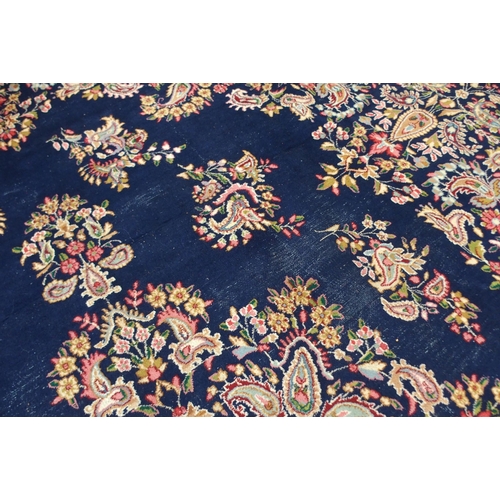 85 - A dark blue ground eastern style wool rug with floral foliate central medallion and borders, 501cm l... 