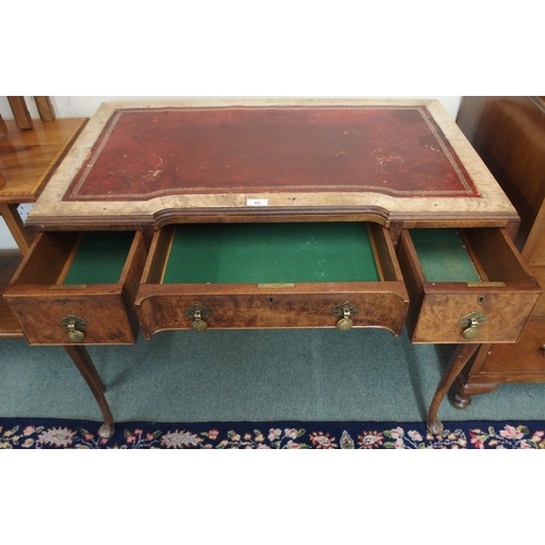 89 - An early 20th century walnut ladies writing desk with red leather skiver over three drawers on cabri... 