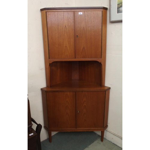 96 - A mid 20th century teak corner cabinet with pair of cabinet doors over open shelf over pair of cabin... 