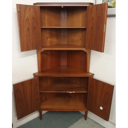 96 - A mid 20th century teak corner cabinet with pair of cabinet doors over open shelf over pair of cabin... 