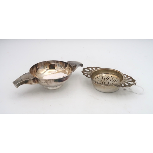 410 - A silver tea strainer, the handles formed as openwork shells, by Royal Irish Silver Co, Sheffield 19... 