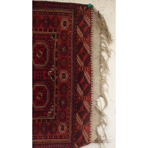 105 - A red ground Bokhara rug with all over medallion design and geometric borders