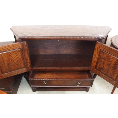 109 - A 20th century stained oak two door court cabinet and a oak single drawer side table (2)