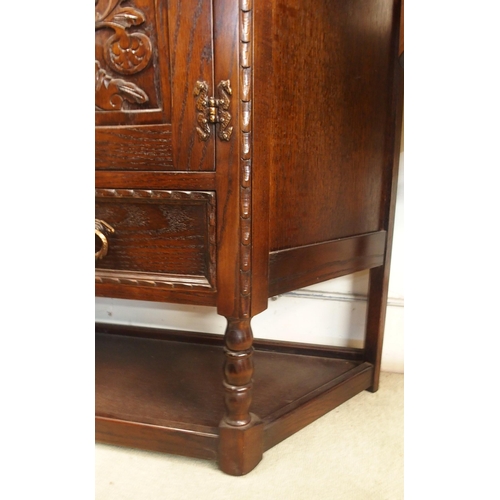 109 - A 20th century stained oak two door court cabinet and a oak single drawer side table (2)