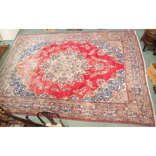 147 - A red ground Tabriz rug with blue and white floral central medallion, matching spandrels and a blue ... 