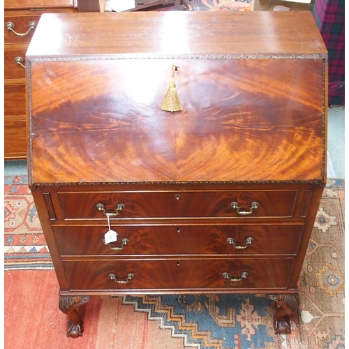 176 - A 20th century mahogany writing bureau with fitted fall front writing compartment over three drawers... 