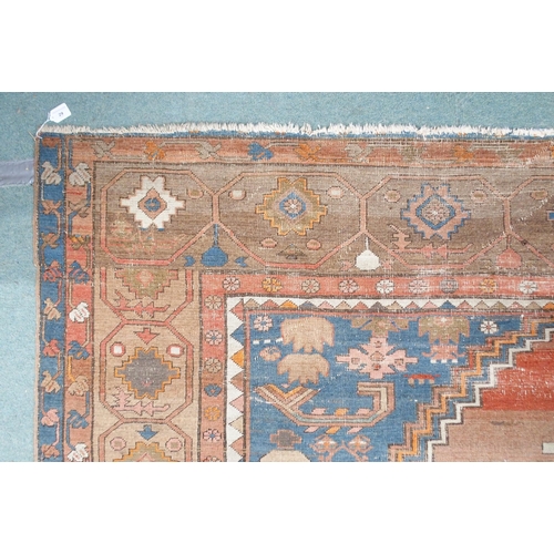 29 - A terracotta ground Belouche rug with geometric central medallion light blue spandrels and beige bor... 