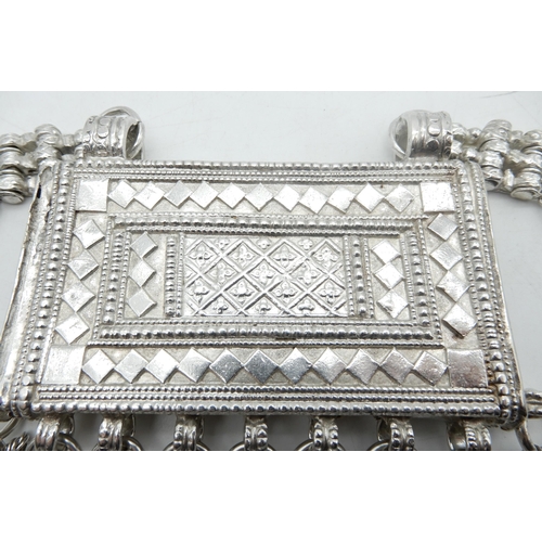 325 - An Omani white metal hirz / koran box, the box with emobssed geometric decoration, with attached bel... 