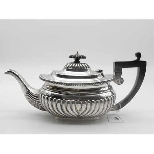 333 - A late Victorian silver tea pot, the body and domed lid lobed, the rim gadrooned, with ebonised hand... 