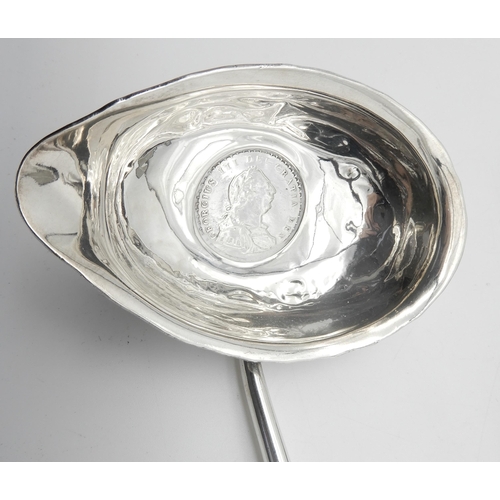 336 - A Georgian white metal toddy ladle, with turned whalebone handle, with a George III 1 Shilling solde... 