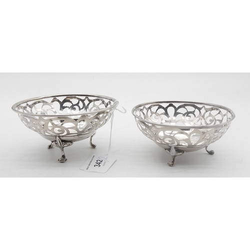 342 - A matched pair of silver bon bon dishes, with pierced floral openwork, on three fleur de lys scroll ... 