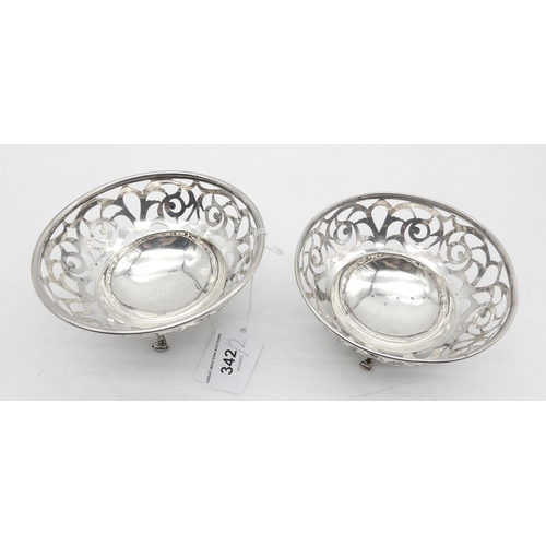 342 - A matched pair of silver bon bon dishes, with pierced floral openwork, on three fleur de lys scroll ... 