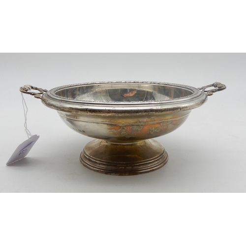 346 - A twin handled silver bowl, the rim with moulded decoration, with cast handles, on a footed circular... 