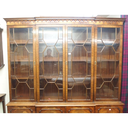 46 - A 20th century mahogany breakfront glazed bookcase with dentil cornice over four astragal glazed doo... 