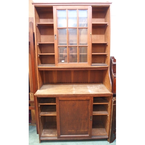 69 - A 20th century pine kitchen cabinet with glazed sliding doors over open compartment over sliding pan... 