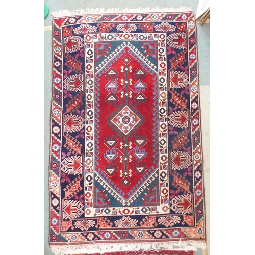 94 - A red ground Balouch rug with geometric central panel and dark blue borders