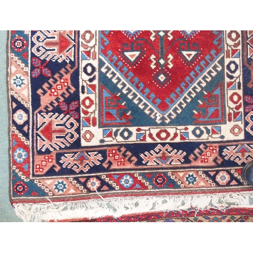 94 - A red ground Balouch rug with geometric central panel and dark blue borders