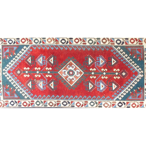 94 - A red ground Balouch rug with geometric central panel and dark blue borders