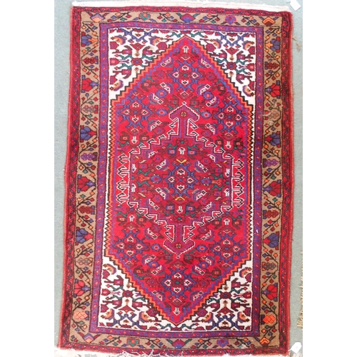 95 - A red ground Balouch rug with geometric central panel and beige border