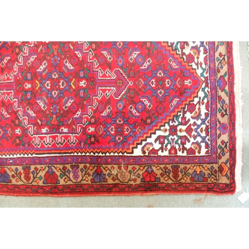 95 - A red ground Balouch rug with geometric central panel and beige border