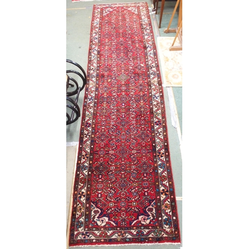 96 - A red ground Persian runner with all over geometric design, white spandrels and a multicoloured flow... 