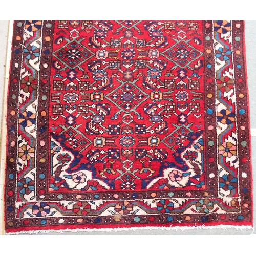 96 - A red ground Persian runner with all over geometric design, white spandrels and a multicoloured flow... 