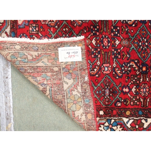 96 - A red ground Persian runner with all over geometric design, white spandrels and a multicoloured flow... 