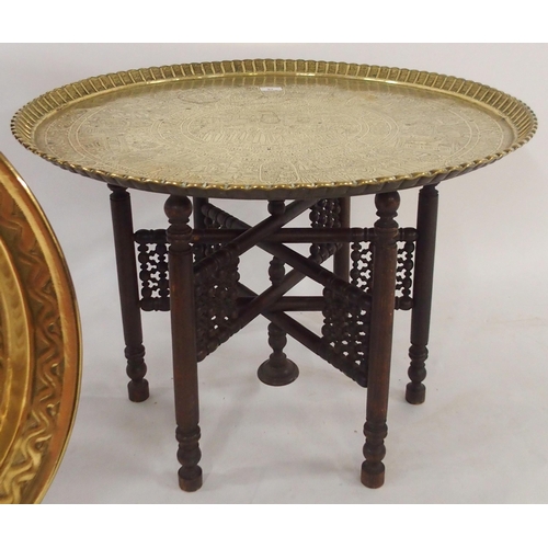 97 - A 20th century Moorish style brass topped folding table, An ebonised circular topped table with turn... 