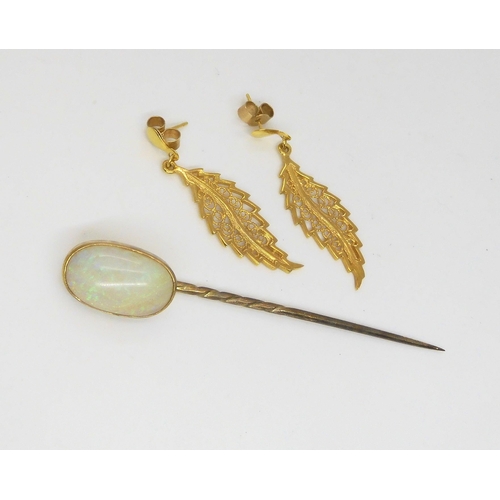 587 - A yellow metal lapel pin set with a large white opal, dimensions approx 15.5mm x 9.5mm x 4.6mm, weig... 